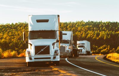 pexels-photo-2199293-2199293 Three semi trucks driving on a highway through a forested landscape in Arizona.