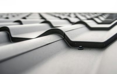 roof-plate-tiles-brick-black-48882-48882 Close-up view of a metal roof's wavy design showcasing rivets and structural detail.